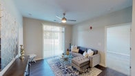 This single-floor residence on Satori Pkwy in Avon, Indiana, presents a well-designed layout with a cohesive, modern aesthetic throughout. The living area serves as the heart of the unit, featuring dark hardwood-style flooring, a ceiling fan with integrated lighting, and a large sliding glass door fitted with vertical blinds that invite generous natural light and provide outdoor access. The open feel of the space is well-suited for comfortable everyday living.

The kitchen is outfitted with gray shaker-style cabinetry, white quartz countertops, a classic subway tile backsplash, and a full suite of stainless steel appliances, including a range, over-the-range microwave, and refrigerator. Dark hardwood-style flooring continues here, maintaining visual consistency with the main living areas.

The bedrooms feature soft, neutral-toned carpet and windows with blinds that allow natural light while maintaining privacy. The bathrooms are finished with gray vanity cabinetry, quartz countertops, and hardwood-style flooring. One bathroom includes a tub-shower combination, while another features a streamlined layout with a single vanity. Together, these spaces reflect a clean, contemporary design throughout the entire unit.