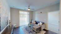 This single-floor residence on Satori Pkwy in Avon, Indiana, presents a well-designed layout with a cohesive, modern aesthetic throughout. The living area serves as the heart of the unit, featuring dark hardwood-style flooring, a ceiling fan with integrated lighting, and a large sliding glass door fitted with vertical blinds that invite generous natural light and provide outdoor access. The open feel of the space is well-suited for comfortable everyday living.

The kitchen is outfitted with gray shaker-style cabinetry, white quartz countertops, a classic subway tile backsplash, and a full suite of stainless steel appliances, including a range, over-the-range microwave, and refrigerator. Dark hardwood-style flooring continues here, maintaining visual consistency with the main living areas.

The bedrooms feature soft, neutral-toned carpet and windows with blinds that allow natural light while maintaining privacy. The bathrooms are finished with gray vanity cabinetry, quartz countertops, and hardwood-style flooring. One bathroom includes a tub-shower combination, while another features a streamlined layout with a single vanity. Together, these spaces reflect a clean, contemporary design throughout the entire unit.