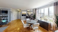 Located in the heart of Los Angeles, this single-floor residence at 6200 W 3rd St offers a thoughtfully designed layout with a seamless blend of comfort and style. The open-concept living and dining area is anchored by classic parquet hardwood flooring and adorned with elegant crown molding, creating a refined yet inviting atmosphere. Large windows flood the space with natural light while framing views of the surrounding cityscape. The living area provides ample room for relaxed seating arrangements, while the adjacent dining space features a round table setup ideal for entertaining. The kitchen is efficiently laid out with white cabinetry, granite countertops, a gas range, and full-size appliances. The bedroom is a serene retreat, highlighted by a two-tone blue and light gray color palette, plush carpeting, and generous window exposure that continues the theme of natural light throughout the home. A dedicated workspace area within the bedroom adds functional versatility. The full bathroom is clean and classic, featuring a tiled tub-shower combination with a chrome curtain rod, a pedestal sink, and neutral gray wall tones. Throughout the residence, a consistent cool gray color scheme ties each room together, contributing to a cohesive and modern aesthetic well-suited to Los Angeles living.