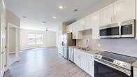 Located at 523 S Madison Ave in Greenwood, Indiana, this 1-bedroom, 1-bathroom unit offers a well-designed, single-floor layout with modern finishes throughout. The open-concept kitchen and living area forms the heart of the home, where white shaker-style cabinetry, light quartz countertops, and a subway tile backsplash create a clean, contemporary aesthetic. The kitchen is fully equipped with stainless steel appliances, including a French door refrigerator with ice maker, electric range, built-in microwave, and dishwasher. Light wood-look luxury vinyl plank flooring extends across the main living areas, complemented by a ceiling fan and windows that allow natural light to fill the space. The bedroom features plush carpeting, a ceiling fan, and dual windows with outdoor views, creating a comfortable retreat. Two closets provide ample storage. The full bathroom is appointed with wood-look flooring, a white vanity with countertop storage, and a tiled tub-shower combination. Additional utility and laundry rooms add everyday convenience. The overall ambiance is bright, clean, and move-in ready, with a neutral color palette that suits a variety of styles.