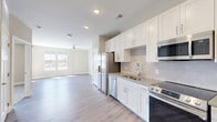 Located at 523 S Madison Ave in Greenwood, Indiana, this 1-bedroom, 1-bathroom unit offers a well-designed, single-floor layout with modern finishes throughout. The open-concept kitchen and living area forms the heart of the home, where white shaker-style cabinetry, light quartz countertops, and a subway tile backsplash create a clean, contemporary aesthetic. The kitchen is fully equipped with stainless steel appliances, including a French door refrigerator with ice maker, electric range, built-in microwave, and dishwasher. Light wood-look luxury vinyl plank flooring extends across the main living areas, complemented by a ceiling fan and windows that allow natural light to fill the space. The bedroom features plush carpeting, a ceiling fan, and dual windows with outdoor views, creating a comfortable retreat. Two closets provide ample storage. The full bathroom is appointed with wood-look flooring, a white vanity with countertop storage, and a tiled tub-shower combination. Additional utility and laundry rooms add everyday convenience. The overall ambiance is bright, clean, and move-in ready, with a neutral color palette that suits a variety of styles.