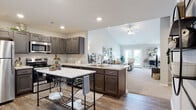 Located at 6400 Birch Trail Ln. in Columbus, Ohio, this single-story home offers a well-designed, open-concept layout that seamlessly connects the kitchen, dining, and living areas. The kitchen is appointed with rich dark-toned cabinetry, light granite countertops, stainless steel appliances, and a central island, all set atop durable hardwood-style flooring. The space opens naturally into a bright living room highlighted by vaulted ceilings, a ceiling fan, and access to the outdoors through French doors that invite natural light throughout. The living area features plush carpeting and a neutral color palette that creates a warm, inviting atmosphere. The bedrooms are generously sized with soft carpet flooring, large windows with natural light, and dedicated closet space, providing comfortable and private retreats. The bathroom is finished with elegant marble-style tile flooring, dark cabinetry with light countertops, and a full tub-shower combination. A dedicated laundry room accommodates full-size side-by-side washer and dryer units with built-in shelving for added convenience. Throughout the home, a consistent neutral tone and thoughtful finishes create a cohesive and functional living environment.