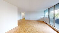 Located at 301 Dixon Road in Toronto, this 2-bedroom, 1-bathroom unit offers a well-organized single-floor layout with a clean, bright aesthetic throughout. Warm parquet flooring is a defining characteristic of the space, running consistently through the living room, bedrooms, hallway, and closet, lending a classic and cohesive feel to the interior.

The spacious living room is generously proportioned, featuring large windows that invite abundant natural light and provide views of the surrounding greenery and cityscape. The open feel of the room makes it well-suited for a variety of furniture arrangements.

The primary bedroom is a comfortable size, equipped with wide windows offering pleasant outdoor views of trees and neighbouring buildings, along with a baseboard heating unit. A second bedroom provides additional flexibility, also finished with parquet flooring and white walls. Both bedrooms benefit from good natural light. A dedicated closet space features built-in shelving and hanging rods, offering practical storage solutions.

The bathroom is finished with classic white subway tile surrounding a full soaking tub and shower combination, complemented by chrome fixtures for a clean, timeless look. A hallway connects the main living areas, maintaining a practical and efficient flow throughout the unit.