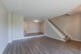 Located at 723 Berkshire Dr in London, Ontario, this two-storey home offers a well-organized layout across two floors, comprising three bedrooms, three bathrooms, a living room, a combined dining room and kitchen, a hallway, and a closet. The main floor welcomes you with durable hardwood-style vinyl flooring that flows through the living and dining areas. The living room is a bright, inviting space highlighted by a large bay window that frames views of the surrounding greenery and front yard, filling the room with natural light. A carpeted staircase with a white railing connects to the upper level. The kitchen features white cabinetry, a functional countertop with sink, and white appliances, offering a clean and practical workspace. The upper floor is finished with plush carpet throughout the bedrooms, lending a comfortable and quiet feel. The primary bedroom provides a generous amount of space and includes a closet. The additional bedrooms are well-proportioned, each featuring windows with views of mature trees and the surrounding neighbourhood. The bathrooms are finished cleanly, with one featuring a tiled tub surround. Neutral grey and beige tones are used throughout, creating a cohesive and calm ambiance across all rooms.