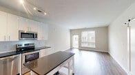 Located at 2803 Poag St in Alexandria, Virginia, this well-appointed one-bedroom, one-bathroom residence offers a thoughtfully designed single-floor layout. The open-concept kitchen and living area serves as the heart of the home, showcasing rich hardwood-style flooring, neutral-toned walls, and a sliding barn door that adds a contemporary architectural touch. The kitchen is outfitted with sleek white cabinetry reaching to the ceiling, dark granite countertops, a classic subway tile backsplash, stainless steel appliances including a refrigerator, range, microwave, and dishwasher, and track lighting overhead. A large window and direct access to a private balcony allow natural light to fill the living space. The bedroom features plush carpeting, soft neutral walls, and connects directly to a generously sized walk-in closet equipped with wire shelving and hanging rods for ample storage. The bathroom is clean and modern, featuring full subway tile surrounding a soaking tub and shower combination, with chrome fixtures and tile flooring. Throughout the residence, the design is clean, contemporary, and move-in ready, offering a comfortable and functional living environment in a convenient Northern Virginia location.