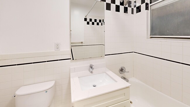 Cuarto de baño con inodoro, lavabo y bañera. - 645 Stockton Street