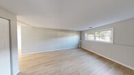 Located at 200 Bedford Rd in Woburn, MA, this well-appointed one-bedroom, one-bathroom unit offers a thoughtfully designed layout across a single floor. Light-toned hardwood flooring runs throughout the living areas and bedroom, contributing to a bright, cohesive aesthetic. The living area is generously sized, featuring soft gray walls, crisp white trim, and a large multi-pane window that draws in natural light and frames outdoor views of surrounding greenery. The kitchen is efficiently organized with white shaker-style cabinetry, light countertops, subway tile backsplash, and a full suite of stainless steel appliances including a gas range, built-in microwave, dishwasher, and refrigerator. A window above the sink adds natural light to the workspace. The spacious primary bedroom includes recessed lighting, a window for additional natural light, and two side-by-side closets offering ample storage. The bathroom is finished in a clean, all-white palette with subway tile wall accents, a tiled tub/shower combination with a decorative mosaic border, a white vanity, and gray tile flooring. An entry hallway provides a functional transition between rooms, completing this efficiently designed and move-in ready home.