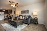 Located at 135 Old Gray Station Rd in Johnson City, TN, this two-story home offers a thoughtfully designed layout across two levels. The kitchen is a standout feature, showcasing rich dark wood cabinetry, light granite countertops, stainless steel appliances including a French door refrigerator and electric range, and a peninsula with pendant lighting — all set atop light hardwood-style flooring. The adjacent dining area and living room provide an open, connected feel, with the living space featuring the same warm flooring, ceiling fan, and neutral tones throughout. Multiple bedrooms are spread across the home, each carpeted and equipped with ceiling fans for comfort. The primary bedroom features a queen bed setup with modern wood furnishings, while two additional bedrooms each accommodate twin beds, making them well-suited for shared use. Bathrooms include a full bath with a tub/shower combination and dark vanity cabinetry, as well as a powder room with a pedestal sink and round mirror — both finished with brushed nickel fixtures and light wood-style flooring. The home's clean, neutral palette and practical layout make it a versatile and comfortable space.