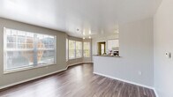 Located at 2600 Harrison St in Kansas City, MO, this one-bedroom, one-bathroom residence offers a thoughtfully designed single-floor layout. The open-concept living and kitchen area is anchored by a charming bay window arrangement that floods the space with natural light and frames views of the surrounding greenery. Durable wood-style flooring runs throughout the main living areas, complementing the neutral, light gray walls.

The galley-style kitchen is well-equipped with stainless steel appliances, a electric range, refrigerator, and dishwasher, set against a tile backsplash. Dark granite-style countertops contrast cleanly with crisp white cabinetry, and a breakfast bar provides a convenient pass-through to the living area.

The bedroom features plush carpeting, two windows for natural light, and direct access to both a walk-in closet with built-in wire shelving and a second closet. The full bathroom offers a single vanity with granite-style counters, white cabinetry, wood-style flooring, and a tub-shower combination. A dedicated utility room rounds out the layout. Track lighting in the living area and ample storage throughout make this a functional and comfortable space.