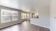 Located at 2600 Harrison St in Kansas City, MO, this one-bedroom, one-bathroom residence offers a thoughtfully designed single-floor layout. The open-concept living and kitchen area is anchored by a charming bay window arrangement that floods the space with natural light and frames views of the surrounding greenery. Durable wood-style flooring runs throughout the main living areas, complementing the neutral, light gray walls.

The galley-style kitchen is well-equipped with stainless steel appliances, a electric range, refrigerator, and dishwasher, set against a tile backsplash. Dark granite-style countertops contrast cleanly with crisp white cabinetry, and a breakfast bar provides a convenient pass-through to the living area.

The bedroom features plush carpeting, two windows for natural light, and direct access to both a walk-in closet with built-in wire shelving and a second closet. The full bathroom offers a single vanity with granite-style counters, white cabinetry, wood-style flooring, and a tub-shower combination. A dedicated utility room rounds out the layout. Track lighting in the living area and ample storage throughout make this a functional and comfortable space.