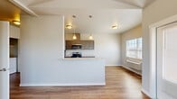 This thoughtfully designed 2-bedroom, 2-bathroom residence offers a practical and modern single-floor layout. The open-concept kitchen and living area serves as the heart of the home, featuring warm wood-look flooring, neutral tones, and natural light from well-placed windows. The kitchen is fully equipped with stainless steel appliances — including an electric range, microwave, and dishwasher — complemented by gray shaker-style cabinetry, granite-look countertops, and pendant lighting above a peninsula that doubles as a breakfast bar. An in-unit washer and dryer hookup adds everyday convenience. Both bedrooms are comfortably sized with wood-look flooring, large windows that invite natural light and outdoor views, and clean, neutral wall finishes. The primary bedroom features its own private bathroom with a walk-in shower, a vanity with granite-look countertops, and dark cabinetry. The second bathroom is equipped with a full soaking tub and shower combination, grab bars, and matching finishes. Throughout the unit, clean lines, consistent flooring, and a cohesive neutral palette create a calm and livable ambiance suited for modern everyday living.