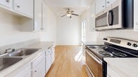 Located at 3711 W 230th St in Torrance, California, this single-floor residence offers two bedrooms and three bathrooms within a well-organized, efficiently designed layout. The interior is bright and clean throughout, characterized by crisp white walls, textured ceilings, and a consistent mix of light wood-style flooring in the main areas and plush carpeting in the bedrooms.

The galley-style kitchen is a functional highlight, featuring white cabinetry, light stone countertops, stainless steel appliances including a range and built-in microwave, a double sink, and a dishwasher. Track lighting and a ceiling fan add both practicality and style to the space, while a window at the end draws in natural light.

The living area is carpeted and opens directly to a private balcony through a wide sliding glass door, offering views of the surrounding neighborhood and filling the room with abundant natural light. The primary bedroom is a generously sized, carpet-floored retreat with a window providing additional natural light.

The bathrooms are clean and functional, with white cabinetry, light countertops, large mirrors, and glass-enclosed shower-tub combinations. A hallway connects the bedrooms and bathrooms, maintaining an efficient flow throughout the home. Overall, the space presents a tidy, comfortable environment in a desirable Torrance location.