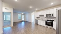 This well-appointed 2-bedroom, 2-bathroom residence in Jacksonville, Florida, offers a thoughtfully designed single-level layout that balances modern finishes with everyday functionality. The open-concept living and kitchen area serves as the heart of the home, featuring warm wood-style plank flooring, recessed lighting, and a ceiling fan. Large windows and a glass-panel door flood the living space with natural light while providing outdoor access. The kitchen is outfitted with white shaker cabinetry, granite countertops, a subway tile backsplash, and a full suite of stainless steel appliances including a dishwasher, range, microwave, and French door refrigerator. Both bedrooms are carpeted and include ceiling fans and windows with exterior views. The spacious primary bedroom connects to a well-designed en-suite bathroom featuring a glass-enclosed walk-in shower with marble-style tile, a granite-topped vanity, and wood-style flooring. Each bedroom is complemented by a walk-in closet with wire shelving for ample storage. A dedicated laundry room houses a full-size washer and dryer. The hallway connects all rooms efficiently, contributing to the home's clean, functional flow throughout.