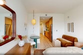 Located at 36 Journal Square Plaza in Jersey City, NJ, this thoughtfully designed one-bedroom, one-bathroom residence makes efficient use of its intimate footprint across a single floor. The open layout connects the bedroom and den area seamlessly, creating a cohesive living space bathed in natural light from large windows that frame impressive city skyline views. Light-toned hardwood flooring runs throughout, lending warmth and visual continuity to every room.

The galley-style kitchen is outfitted with clean-lined light wood cabinetry, white countertops, a subway tile backsplash, and stainless steel appliances including a refrigerator, range, microwave, and dishwasher — delivering a fully functional cooking space in a compact, well-organized form.

The bedroom comfortably accommodates a full-sized bed and features a large picture window overlooking the Jersey City and Manhattan skyline, providing a striking urban backdrop. The space also includes a den that offers additional flexibility for work or relaxation. Two closets provide practical storage, and an in-unit laundry area adds everyday convenience.

The bathroom is finished with neutral tile flooring and clean white walls, maintaining the home's consistent modern and minimalist aesthetic throughout. Recessed lighting and crisp white walls keep the entire residence feeling bright and airy.