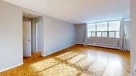 Located at 39 Parkcrest Drive, Suite 318 in Toronto's Scarborough neighbourhood, this one-bedroom, one-bathroom unit offers a practical and comfortable layout across a single floor. Classic parquet flooring runs throughout the living, dining, and bedroom areas, lending warmth and character to the space.

The combined living and dining area is generously proportioned, bathed in natural light streaming through large windows fitted with sheer curtains. Baseboard heating runs along the exterior walls, ensuring year-round comfort. The open sightlines between the living and dining zones create an airy, connected feel.

The kitchen has been updated with grey shaker-style cabinetry, stone-look countertops, a mosaic tile backsplash, and durable stone tile flooring — a functional and stylish space for cooking and meal prep. White appliances, including a freestanding range and refrigerator, complete the setup.

The bedroom is a comfortable, well-lit room featuring its own large window with outdoor views, a sliding-door closet for ample storage, and the same warm parquet flooring found throughout the unit.

The bathroom is clean and classic, featuring a full soaker tub with an overhead shower, white subway-style tile surround, and chrome fixtures. The unit also includes a dedicated closet near the entry for additional storage.