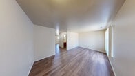 Located at 5825 Emerald Springs in Detroit, Michigan, this two-story home offers four bedrooms and two full bathrooms across a well-organized floor plan. The main level features an open-concept kitchen and living area finished with durable hardwood-style flooring. The kitchen is equipped with rich dark wood cabinetry, light countertops, and black appliances including a refrigerator, range, and dishwasher, alongside a double sink beneath a window that brings in natural light. The adjacent living area is bright and open, with a large window dressed in vertical blinds and direct access to the front entry. The upper level hosts the bedrooms, each featuring soft carpet flooring and windows that offer views of the surrounding neighborhood. The primary bedroom includes a dedicated walk-in closet outfitted with wire shelving and hanging rods. Both bathrooms are consistently finished with hardwood-style flooring, dark wood vanities, light countertops, and full tub-shower combinations. A hallway connects the upper-level rooms, and the staircase provides a clear transition between floors. Neutral wall tones and clean finishes throughout give the home a bright, move-in-ready feel.