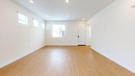 Located at 15912 Chase Rd in Fontana, CA, this two-story home offers a well-organized layout spread across two floors. The ground floor hosts the main living areas, including an open-concept kitchen and living room, a garage with an automatic opener and electrical panel access, and a hallway connecting the spaces. The kitchen is outfitted with crisp white shaker cabinetry, stainless steel appliances including a refrigerator with water dispenser, dishwasher, range, and microwave, along with a single-basin sink beneath a window. The living area is bright and spacious, with recessed lighting, light wood-style flooring, and a sliding glass door leading to the rear yard. A pedestal sink bathroom is also found on this level. Upstairs, three bedrooms are accessible via a staircase and hallway. The generously sized primary bedroom features dual windows, recessed lighting, a walk-in closet, and an en suite bathroom with a vanity. The additional bedrooms are well-proportioned and share natural light through slatted blinds. Light wood-style flooring runs consistently throughout both floors, tying together the home's clean, contemporary aesthetic.