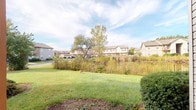 Located at 2332 Asics Dr in Hilliard, Ohio, this single-floor property sits within an established residential neighborhood. The outdoor area showcases a well-maintained, open grassy lot that provides a sense of openness and space. A natural buffer of tall reeds and native vegetation lines the rear of the property, offering a degree of privacy and a connection to the local landscape. Mature trees punctuate the surroundings, adding seasonal greenery and visual interest to the setting. The property backs up to views of neighboring multi-story residential buildings, reflecting the established and community-oriented nature of the area. The lot benefits from natural light throughout the day, with an open sky that enhances the outdoor ambiance. The combination of maintained lawn, natural vegetation, and tree coverage creates a balanced outdoor environment. The property's single-floor layout and generous lot contribute to its accessible and practical character. Its position within the Hilliard community places it near local amenities, schools, and thoroughfares, making it a well-situated property within this growing Columbus-area suburb.