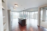 This 740-square-foot one-bedroom, one-bathroom residence at SkyHouse Dallas delivers a sophisticated high-rise living experience defined by sweeping Dallas skyline views and contemporary design. The open-concept kitchen and living area features rich hardwood flooring, exposed concrete ceilings, and dramatic floor-to-ceiling glass walls with sliding doors that open to a private balcony. The kitchen is appointed with dark espresso cabinetry, stainless steel appliances including a refrigerator, microwave, and range, a white subway tile backsplash, and a granite-topped center island with pendant lighting above. The living area benefits from abundant natural light and direct city views. The 140-square-foot bedroom offers plush carpeting, an exposed concrete ceiling, and sliding glass doors to a second balcony with additional skyline views, alongside a walk-in closet with built-in shelving. The bathroom features a dark granite vanity with an undermount sink, modern cabinetry, tile flooring, and a glass-enclosed walk-in shower with tiled walls. A hallway connects all spaces efficiently, completing this well-appointed urban retreat.