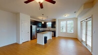 This single-floor residence at Spring House Apartments offers a thoughtfully designed open-concept layout that seamlessly connects the kitchen and living areas. The kitchen is a standout feature, showcasing dark espresso cabinetry, stainless steel appliances, granite countertops, and a central island with pendant lighting overhead. Track lighting and a window above the sink provide additional illumination, while light wood-style flooring runs throughout the main living space, enhancing the bright and airy atmosphere.

The living area is generously proportioned, benefiting from multiple windows that invite natural light and offer views of the surrounding community. A ceiling fan adds comfort to this central gathering space. The bedrooms are carpeted for warmth and comfort, each featuring windows with blinds and ceiling fans for ventilation.

The bathroom is well-finished, featuring a dark vanity with a granite-topped double sink, a large mirror, wood-style flooring, and a soaking tub with full tile surround. A dedicated laundry area with washer connections and built-in shelving adds practical convenience. Overall, the unit presents a clean, contemporary aesthetic with consistent finishes throughout.