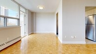 Located at 225 Van Horne Ave in Toronto's M2J neighbourhood, this 2-bedroom, 1-bathroom unit offers a well-organized single-floor layout that makes efficient use of its space. Polished parquet flooring runs throughout the living areas and both bedrooms, lending a warm, classic character to the interior.

The living room is bright and open, benefiting from large windows that frame views of the surrounding cityscape and fill the room with natural light. Baseboard heating runs along the walls, ensuring comfortable warmth throughout.

The kitchen features cream-toned cabinetry, dark countertops, a subway tile backsplash, light tile flooring, and stainless steel appliances including a full-size refrigerator — a clean, functional space well-suited for everyday cooking.

The primary bedroom is generously sized, with a large window offering city views, parquet flooring, and baseboard heating. The second bedroom is comfortably proportioned, also featuring parquet flooring and a window with outdoor views. Both bedrooms include closet storage, with the primary bedroom featuring a double closet.

The bathroom is finished with white subway tile surrounding a full soaking tub, complemented by grey accent tile above — clean and classic in design. Two hallways connect the rooms, contributing to a practical and efficient flow throughout the unit.