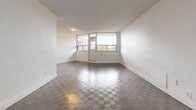 Located at 6151 Bathurst St in North York, Toronto, this 2-bedroom, 1-bathroom unit offers a thoughtfully laid-out single-floor plan. The entrance opens to a hallway with a mirrored sliding-door closet, providing convenient storage. The kitchen is a standout feature, outfitted with crisp white shaker cabinetry, dark countertops, a classic subway tile backsplash, gleaming porcelain tile flooring, and a full suite of stainless steel appliances including a dishwasher, range, and over-the-range microwave. A dedicated dining area flows naturally from the kitchen. The living room is bright and spacious, featuring distinctive parquet-style flooring and large windows that frame outdoor views and invite ample natural light. A private balcony extends from the living area, offering a serene outlook over lush, mature trees. Both bedrooms are generously sized with the same parquet flooring, neutral white walls, and natural light from exterior windows. The primary bedroom includes a mirrored sliding closet. The bathroom is finished with white subway tile surrounding a soaker tub and shower combination. Multiple closets throughout the unit provide excellent storage.