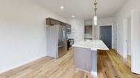 This 560 square foot apartment in Fitchburg, WI offers a modern and efficient living space. The single-story layout comprises two bedrooms, including a primary bedroom of 140 square feet, and one bathroom. The heart of the home is a contemporary kitchen, featuring sleek stainless steel appliances, ample cabinetry in a neutral tone, and a spacious island with a white countertop that doubles as a dining area.

Large windows throughout the apartment flood the rooms with natural light, creating an open and airy atmosphere. The living spaces are adorned with plush carpeting, while the kitchen and bathroom boast attractive hardwood flooring. Climate control is ensured with both baseboard heating and a wall-mounted air conditioning unit.

The bathroom is well-appointed with a modern vanity and ample storage space. The apartment also includes practical features such as an in-unit laundry area and built-in storage solutions. The neutral color palette and clean lines throughout provide a blank canvas for personalization, making this compact yet functional apartment an ideal space for comfortable urban living.