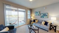 This single-story residence offers a thoughtfully designed layout that balances open communal spaces with comfortable private retreats. The kitchen serves as a functional centerpiece, featuring warm honey-toned cabinetry, dark granite countertops, a peninsula island with an integrated sink, stainless steel appliances including a refrigerator, dishwasher, and range, recessed lighting, and wood-look tile flooring that extends throughout the space.

The open-concept design connects the kitchen seamlessly to both the dining area and the living room. The living room is well-lit by a bank of large windows fitted with vertical blinds, allowing abundant natural light, and is finished with neutral carpet. A dedicated dining area sits adjacent, providing a distinct space for meals.

The bedrooms are carpeted and receive natural light through sizable windows. One room features ceiling fan lighting and offers versatility as a bedroom or home office. The primary bedroom is generously proportioned with ample wall space.

The bathrooms are consistently finished with granite-topped vanities, warm wood cabinetry, wood-look tile flooring, and tub-shower combinations with white tile surrounds, maintaining a cohesive aesthetic throughout the residence.
