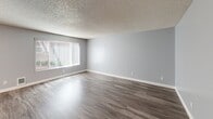 Located at 17525 80th Ave NE in Kenmore, Washington, this one-bedroom, one-bathroom unit offers a practical and well-designed single-floor layout. Throughout much of the home, durable wood-look flooring and soft gray walls create a clean, cohesive aesthetic complemented by textured ceilings.

A welcoming hallway with a wall-mounted light fixture guides you into the main living areas. The spacious living room is flooded with natural light through a large window dressed with vertical blinds, making the room feel open and airy.

The galley-style kitchen is efficiently designed with white shaker cabinetry lining both walls, light quartz-style countertops, a stainless steel sink, and black appliances including a refrigerator and electric range. A built-in microwave and ample cabinet storage make this kitchen highly functional.

The bedroom features plush wall-to-wall carpeting, a window with blinds for natural light, and a wide sliding-door closet offering generous storage. The full bathroom includes a tub-shower combo with a handheld showerhead, chrome fixtures, and a window that brings in natural light.

Clean finishes, neutral tones, and a thoughtful layout make this a comfortable and move-in-ready home in Kenmore, WA.