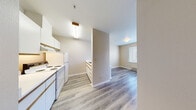 This efficiently designed studio unit at 334 Wells Ave S in Renton, Washington offers a practical and functional single-floor layout. The living area is bright and open, featuring light gray vinyl plank flooring that runs throughout the entire space, complementing the warm neutral-toned walls and crisp white baseboards. Two windows fitted with horizontal blinds allow natural light to fill the room while offering views of the surrounding neighborhood, and baseboard heaters provide consistent warmth. A built-in shelving unit adds convenient storage directly within the living space. The kitchenette area is equipped with white cabinetry and appliances, offering essential cooking functionality in a compact footprint. A large sliding closet with natural wood-grain panel doors provides generous storage capacity and serves as a defining architectural element of the space. The bathroom is neatly appointed with a wood-toned vanity featuring ample drawer storage, a white countertop with an integrated sink, a toilet, and a towel bar, all finished with the same cohesive vinyl plank flooring. The overall design is clean, minimal, and move-in ready, making this unit a practical option in the Renton area.