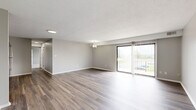 Located at 8171 W Mill St in Cleves, Ohio, this 2-bedroom, 2-bathroom single-floor unit offers a well-designed layout with a cohesive, modern aesthetic throughout. The open-concept kitchen and living area serves as the heart of the home, featuring wood-style luxury vinyl plank flooring, neutral gray walls, and a stylish orb chandelier that adds a contemporary touch. The kitchen is equipped with stainless steel appliances—including a refrigerator, electric range, and over-the-range microwave—complemented by white shaker-style cabinetry, granite-look countertops, and a stainless steel sink. The adjoining living area extends to a sliding glass door with vertical blinds, allowing natural light to fill the space. Both bedrooms are carpeted and feature windows with outdoor views, providing a quiet and comfortable retreat. The spacious primary bedroom includes two closets and direct access to a bathroom. The two bathrooms are finished with wood-style flooring, gray walls, white vanities, and brushed nickel fixtures; one features a tub/shower combination with built-in shelving, while the other is a compact half-style bath. A dedicated closet provides additional storage. The unit's clean, neutral palette and updated finishes create a move-in-ready living environment.