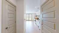 Located at 4150 Yeager Rd in West Lafayette, Indiana, this efficiently designed single-floor unit offers a well-organized layout comprising an open-concept kitchen and living area along with one full bathroom. Light hardwood flooring flows consistently throughout the space, lending warmth and visual continuity.

The kitchen is thoughtfully appointed with crisp white shaker-style cabinetry extending to the ceiling for ample storage, granite-look countertops, a subway tile backsplash, and a full suite of stainless steel appliances including a refrigerator, range, microwave, and dishwasher. The kitchen transitions seamlessly into the living area, which benefits from natural light streaming in through a glass sliding door and an adjacent window fitted with horizontal blinds. The sliding door opens to an outdoor view of the surrounding greenery and neighboring buildings. A ceiling fan with a built-in light fixture provides additional comfort and illumination.

A set of sliding panel doors provides access to a closet, optimizing storage within the living space. The bathroom features light hardwood-style flooring consistent with the rest of the unit, a glass-enclosed shower and tub combination, a toilet, and a vanity with a granite-topped countertop. The overall aesthetic is clean, modern, and neutral, making for a bright and functional living environment.