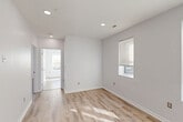 Located in Washington, DC's vibrant Columbia Heights neighborhood, this three-bedroom, one-bathroom residence offers a clean, modern interior with a cohesive and efficient single-floor layout. Light wood-style flooring runs throughout the entire space, lending warmth and continuity from room to room.

The kitchen is a standout feature, outfitted with crisp white shaker cabinets, light countertops, and a full suite of stainless steel appliances including a refrigerator, range, built-in microwave, and dishwasher. Recessed lighting and an open sightline into the combined dining and living area make this kitchen both functional and inviting.

The living and dining area benefits from natural light filtering through windows, creating a bright and airy atmosphere. Each of the three bedrooms is well-proportioned, with the spacious primary bedroom offering ample room for furnishings. The bedrooms feature large windows that invite natural light and views of surrounding greenery, along with dedicated closet space across three closets in the unit.

The bathroom is finished with white subway tile in the tub surround, a shaker-style vanity, and a full bathtub, maintaining the clean, contemporary aesthetic found throughout the home. The overall design emphasizes simplicity, brightness, and modern practicality.