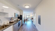 Unit 403 at 42 Broad St W in Mount Vernon, NY presents a thoughtfully designed one-bedroom, one-bathroom residence spread across a single floor. The open layout connects the kitchen and living areas seamlessly, creating an efficient and comfortable flow throughout the space. Light wood-tone flooring runs throughout, complementing the clean white walls and modern finishes.

The kitchen features stainless steel appliances, including a range, microwave, and dishwasher, paired with white cabinetry and a subway tile backsplash. It opens directly toward the living room, which is anchored by a large picture window offering views of the surrounding neighborhood and a glimpse of an outdoor pool below.

The generously sized primary bedroom benefits from its own large window framing views of the cityscape, providing an abundance of natural light. A sliding closet door adds a sleek, space-conscious touch. An additional dedicated office area with a floor-to-ceiling window overlooking the pool area offers an ideal workspace.

The bathroom is finished with large-format floor tiles, clean neutral walls, and chrome fixtures. A hallway connects the rooms efficiently, completing the well-organized layout. This residence combines contemporary design with functional living in the heart of Mount Vernon, NY.
