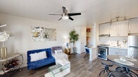 Located at 710 South Hardy Drive in Tempe, Arizona, this efficiently designed studio offers a thoughtfully organized single-floor layout that maximizes every square foot. The open-concept main area seamlessly integrates the living room, dining space, and kitchen, creating a cohesive and functional environment. The living area features wood-look plank flooring, a ceiling fan with integrated lighting, and a large window that draws in natural light while offering views of the surrounding neighborhood. The kitchen is well-appointed with white shaker-style cabinetry, light countertops, a subway tile backsplash, and a full suite of stainless steel appliances, including a range with oven and a full-size refrigerator. Track lighting above the kitchen adds focused illumination to the workspace. A compact dining area adjacent to the kitchen accommodates a round table and seating, enhanced by a decorative mirror on a shiplap-accented wall. The space includes two bathrooms, one of which features a shower-tub combination. A dedicated closet with built-in shelving and a hanging rod provides organized storage. The clean white walls and consistent flooring throughout contribute to a bright, modern ambiance well-suited to efficient urban living.