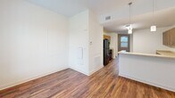Located at 422 Garrett St in Charlottesville, VA, this two-floor space offers a well-designed layout with consistent finishes throughout. Rich hardwood flooring runs across both levels, providing warmth and continuity between rooms.

The kitchen is a standout feature, equipped with warm wood cabinetry offering generous upper and lower storage, light stone-toned countertops, and black appliances including a refrigerator, electric range, and built-in microwave. A staircase is conveniently positioned adjacent to the kitchen, connecting both floors with ease.

The living and common areas are open and bright, with clean white walls, recessed vents, and pendant lighting accents that create a welcoming atmosphere. Large windows throughout the space invite natural light and provide views of the surrounding neighborhood.

The bedrooms are well-proportioned, each featuring hardwood floors, neutral walls, and windows that bring in daylight. Closet space is also available in the bedroom areas.

The bathrooms are finished with grey square tile surrounding the tub-shower combinations, tile flooring, and wood-toned vanity cabinetry with white countertops. One bathroom includes a window for added natural light and ventilation. Both bathrooms reflect a clean, modern aesthetic that complements the overall design of the space.
