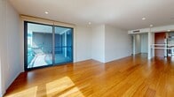 Located in Marina del Rey, this well-appointed 2-bedroom, 2-bathroom residence offers a thoughtfully designed single-floor layout with a blend of modern finishes and natural materials throughout. The open-plan living and dining area is anchored by warm bamboo hardwood flooring that extends seamlessly through the main living spaces, complemented by crisp white walls and recessed lighting. Floor-to-ceiling sliding glass doors flood the living room with natural light and provide direct access to a balcony overlooking the marina, where views of sailboats and the waterfront create a serene backdrop. A wall-mounted fireplace adds a contemporary focal point to the living area. The kitchen is outfitted with rich wood cabinetry, stainless steel appliances including a gas range and refrigerator, a sleek countertop, and a ventilation hood — combining style with functionality. Both bathrooms feature large-format tile flooring, floating wood vanities with integrated white countertops, backlit mirrors, and glass-enclosed showers. The spacious primary bedroom connects directly to one of these bathrooms and includes a generous walk-in closet with dual hanging rods. The secondary bedroom is carpeted and features a sliding glass door with outdoor views. A dedicated walk-in closet and in-unit laundry complete this refined Marina del Rey residence.