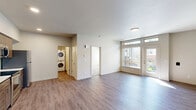 Located at 1650 NE Market Dr in Fairview, Oregon, this 2-bedroom, 1-bathroom unit offers a thoughtfully designed single-floor layout that makes efficient use of its space. The open-concept living area features durable wood-style flooring throughout and is bathed in natural light thanks to large windows and a glass-panel door that opens onto a private balcony with views of the surrounding neighborhood. The well-equipped kitchen includes warm-toned wood cabinetry, a full suite of stainless steel appliances—refrigerator, electric range, built-in microwave, and dishwasher—set against clean white countertops. A dedicated in-unit laundry closet with a stacked washer and dryer adds everyday convenience. The two bedrooms are carpeted for comfort, each featuring windows that allow natural light to fill the rooms. The primary bedroom offers a generous footprint with ample room for furnishings. The bathroom is finished with wood-toned cabinetry, a single vanity with a white countertop, a large mirror, and a bathtub/shower combination, all set on wood-style flooring. Neutral tones and clean finishes throughout give the space a modern, move-in-ready feel.