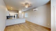 Located at 5190 Cita Dr in Colorado Springs, Colorado, this single-story residence presents a clean, modern interior with a well-considered open-concept design. Light wood-tone flooring runs throughout the main living area, complementing the neutral white walls and creating a bright, cohesive aesthetic. A decorative ceiling light fixture anchors the living space, which also features a wall-mounted ductless mini-split system for efficient climate control.

The kitchen is a standout feature, showcasing white shaker-style cabinetry, a gray subway tile backsplash, and a generously sized granite-topped island with an undermount double sink and modern faucet. Stainless steel appliances, including a refrigerator, range, and over-the-range microwave, complete the kitchen. Recessed lighting provides ample illumination throughout.

The bedrooms are finished with plush carpet and feature sliding or paneled closet doors. One bedroom includes a wall-mounted mini-split unit and a window offering views of the surrounding area. A dedicated laundry area accommodates a stacked washer and dryer unit on wood-tone flooring. The overall interior is clean, contemporary, and move-in ready.