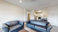 Located at 915 Lovvorn Rd in Carrollton, GA, this single-story unit offers a well-organized, functional layout designed for comfortable everyday living. The open-concept living area features light wood-style flooring, neutral wall tones, and natural light from large windows dressed with horizontal blinds. Seating flows naturally into the adjacent kitchen, which is outfitted with white shaker-style cabinetry, light granite-look countertops, and a full suite of stainless steel appliances including a refrigerator, electric range, and dishwasher. A washer and dryer are conveniently located just off the kitchen. A central hallway connects the bedrooms and bathrooms, maintaining a clear and practical flow throughout the unit. Each bedroom features plush carpeting, natural light, and closet space, with one room including built-in shelving and a dedicated desk area. The unit includes two full bathrooms: one with a single vanity and toilet, and another with a tub-shower combination, vanity with storage, and wood-style tile flooring. The neutral color palette and consistent finishes throughout create a cohesive and livable atmosphere well-suited for a variety of occupants.