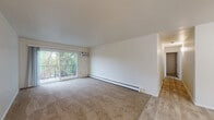 Located at 8580 100th Terrace in Palos Hills, Illinois, this 2-bedroom, 1-bathroom residence offers a practical and comfortable floor plan across a single level. The open living area features a combination of hardwood-style flooring and plush carpeting, with a sliding glass door that leads to a private balcony overlooking lush greenery, filling the space with natural light and outdoor views.

The galley-style kitchen is efficiently designed with ample grey cabinetry on both sides, white countertops, stainless steel appliances including a refrigerator and gas range, a built-in dishwasher, and a single-basin sink — providing generous storage and workspace.

Both bedrooms are carpeted and offer a calm, neutral atmosphere. The spacious primary bedroom features a wide louvered double-door closet, providing substantial storage. The second bedroom includes a window with garden views and baseboard heating. A hallway connects the rooms and leads to the full bathroom, which is equipped with a clean white tub-shower combination and a vanity with light countertops.

A dedicated closet and connecting hallway round out the layout, ensuring convenient organization throughout. The overall aesthetic is clean and neutral, making the space move-in ready and highly adaptable.