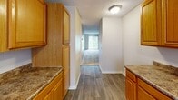 Located at 2821 S Emporia St in Wichita, Kansas, this 2-bedroom, 2-bathroom home offers a well-organized, single-floor layout designed for practical and comfortable living. The kitchen is equipped with warm honey-toned wood cabinetry, dark granite-style countertops, a stainless steel sink, and a full-size refrigerator. Hard surface flooring runs through the kitchen and hallway, which opens naturally into the main living area, creating a cohesive flow throughout the home. Both bedrooms feature neutral-toned carpet, soft wall colors, and textured ceilings, contributing to a calm and understated atmosphere. The primary bedroom offers a generous footprint with access to a dedicated closet, providing practical storage. Windows fitted with horizontal blinds allow natural light to filter into the bedrooms and kitchen. Each bathroom includes a full tub-shower combination with clean, white surround panels and a curtain rod. The textured ceilings are consistent throughout, lending a uniform character to the space. Overall, this home presents a clean, straightforward layout suited for individuals or small households seeking a functional and no-fuss living environment in Wichita.