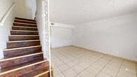 Located at 7627 Jasper Ave in Jacksonville, FL, this two-story home offers a practical and well-organized layout spread across two floors. Light-colored ceramic tile flooring runs throughout the entire home, lending a clean, cohesive look to every room.

The main floor houses the living room, dining room, and kitchen. The living room is a bright, open space featuring a textured ceiling and a decorative staircase railing that adds visual character. The kitchen is equipped with warm oak cabinetry, a double sink, tile backsplash, and a white electric range, complemented by an adjacent pantry for additional storage.

Upstairs, both bedrooms are well-proportioned and finished with the same tile flooring and textured ceilings. The generously sized primary bedroom features two closets, providing abundant storage. The second bedroom also benefits from a window that allows natural light and views of surrounding greenery. A hallway connects the upper-level rooms, with additional closets offering practical storage solutions throughout.

The full bathroom is finished in crisp white, featuring a tub-shower combination, a vanity, and tile walling. With four closets total distributed across both floors, this home is designed to maximize storage in a compact yet functional footprint.