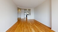 Located at 160 Chapel St in Ottawa's Sandy Hill neighbourhood, this one-bedroom, one-bathroom unit offers a well-planned layout across a single floor. Warm-toned hardwood flooring runs throughout the entire unit, creating a cohesive and inviting atmosphere.

The living area is open and airy, with clean white walls and ample room to arrange furniture comfortably. A standout feature is the curved bay window that floods the space with natural light while framing sweeping city skyline views — an architectural detail that adds both character and brightness to the room.

The kitchen is integrated into the living space in an open-concept configuration, equipped with white cabinetry, a stainless steel refrigerator, and a stainless steel range, providing functional amenities in a compact and efficient layout.

The bedroom is a well-proportioned private retreat, featuring built-in bi-fold closets for generous storage and a window that continues to bring in natural light and city views. Baseboard heating runs along the perimeter, ensuring year-round comfort.

The bathroom is finished in a clean, neutral palette with white tilework, a vanity with storage, a large mirror, and a full-width countertop — practical and neatly appointed. Overall, the unit presents a bright, modern, and functional living space in a central Ottawa location.