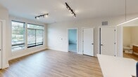 This contemporary 930 square foot apartment offers a well-designed living space with two bedrooms and two bathrooms. The open-concept layout creates a seamless flow between rooms, maximizing the use of space. The primary bedroom, measuring 180 square feet, provides ample room for comfort and relaxation.

The kitchen is a highlight, featuring sleek white cabinetry, stainless steel appliances, and a practical island with a sink, perfect for meal preparation and casual dining. The living area boasts large windows that flood the space with natural light, while track lighting adds a modern touch and provides versatile illumination options.

Both bedrooms are carpeted for comfort and feature large windows, offering views of the surrounding area. The bathrooms are efficiently designed with modern fixtures and finishes, including glass shower enclosures and wood-look flooring that complements the overall aesthetic.

Storage is thoughtfully incorporated throughout the apartment, with built-in closets in the bedrooms and additional cabinet space in the kitchen. The use of neutral colors and clean lines throughout creates a cohesive and contemporary ambiance, making this apartment an ideal choice for those seeking a stylish and low-maintenance living space.