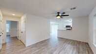 Located at 604 E Sunset St in Springfield, Missouri, this single-story, 3-bedroom, 2-bathroom home offers a well-organized and functional layout with a clean, modern aesthetic throughout. Light wood-look flooring flows seamlessly across the living areas, complemented by crisp white walls and ceiling fans in every room, ensuring comfort year-round.

The open-concept living and dining area connects directly to the kitchen, which features white shaker-style cabinetry, stainless steel appliances including a refrigerator, range, and microwave, and a peninsula with a sink that doubles as a breakfast bar. Natural light fills the space through multiple windows fitted with blinds. The living room provides ample space and direct access to other areas of the home.

The spacious primary bedroom includes its own ceiling fan, a window for natural light, and access to closet space. Three additional closets throughout the home provide generous storage options, with wire shelving systems for organized storage. The two bathrooms are finished in a clean, contemporary style with white vanities, black hardware accents, and matching wood-look flooring.

A utility room and hallway contribute to the home's efficient flow, while the attached garage offers a generous footprint with an automatic opener and interior access door, adding convenience and additional storage potential.