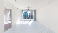 Located high above Uptown Charlotte at 215 North Pine Street, this two-bedroom, two-bathroom residence offers an elevated urban living experience with breathtaking skyline views. The open layout is finished with striking marble-style flooring that flows through the main living area, anchored by floor-to-ceiling glass doors that frame sweeping vistas of the Charlotte cityscape and bathe the space in natural light.

The kitchen is well-appointed with rich cherry wood cabinetry, dark granite countertops, stainless steel appliances including a side-by-side refrigerator and built-in microwave, and a center island — all illuminated by sleek track lighting overhead.

The spacious primary bedroom features plush carpeting, a ceiling fan, and expansive corner glass walls offering panoramic skyline views. The second bedroom is equally comfortable, also carpeted and fitted with a ceiling fan, providing a bright and versatile space.

Both bathrooms are finished with large-format tile, with one showcasing a soaking tub, warm wood vanity, and granite countertops, and the other featuring a glass-enclosed walk-in shower. Clean white walls and neutral tones throughout create a calm, contemporary ambiance reflective of modern high-rise living in the heart of Charlotte.