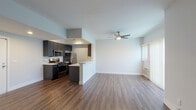 Located at 3324 Castle Heights Ave in Los Angeles, CA, this single-floor unit offers a clean, modern aesthetic throughout. The open-concept layout seamlessly connects the kitchen and living area, creating an expansive, airy feel. Rich, dark hardwood-style flooring runs throughout the space, providing a warm and cohesive look.

The kitchen is well-appointed with dark espresso cabinetry extending to the ceiling for ample storage, crisp white countertops, a stylish tile backsplash, and a full suite of stainless steel appliances including a gas range, microwave, and refrigerator. A peninsula counter opens toward the living area, enhancing the open flow and providing additional workspace.

The living area is bright and generously sized, featuring a ceiling fan with light fixture, a wall-mounted AC unit, and a large window dressed with vertical blinds that allows natural light to fill the room.

The bedroom offers exceptional storage with multiple mirrored sliding-door closets and open shelving built into the walls, all set on the same rich hardwood-style flooring. The bathroom includes a full soaking tub with shower combination, finished in clean white surrounds. The overall ambiance of the space is contemporary and move-in ready, making it a practical and stylish home in a well-situated Los Angeles neighborhood.