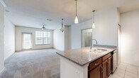 Located at 11405 Billfish Circle in Trinity, FL, this single-floor, 2-bedroom, 2-bathroom residence offers a well-designed layout with a comfortable, functional flow throughout. The open-concept living and dining area is bright and spacious, featuring plush carpeting, a ceiling fan, and large windows that allow natural light to fill the room. A pendant light fixture adds a decorative touch, while a door leads directly to a private balcony.

The kitchen is thoughtfully designed with rich, dark wood cabinetry, granite-style countertops, and a full suite of stainless steel appliances including a refrigerator, range, microwave, and dishwasher. A kitchen island with a built-in sink and pendant lighting above serves as both a prep space and a casual gathering area. Light tile flooring runs throughout the kitchen and extends into the hallway.

Both bathrooms are finished with tile flooring, dark wood vanities with granite countertops, and safety grab bars. One bathroom features a tub/shower combination, while the other includes a glass-enclosed shower. Each bedroom is carpeted and generously sized, with the primary bedroom offering a particularly spacious walk-in closet. Additional closet space is abundant throughout, totaling six closets. A dedicated laundry area and entrance foyer complete this well-appointed home.