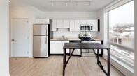 Suite 414 is a thoughtfully designed single-floor unit that blends modern aesthetics with practical functionality. The kitchen serves as a standout feature, outfitted with a full suite of stainless steel appliances including a refrigerator, electric range, built-in microwave, and dishwasher. Crisp white cabinetry extends from counter height to the ceiling, maximizing storage space, while light-toned countertops and a stainless steel sink complete the streamlined look. Track lighting overhead ensures the kitchen is well-illuminated throughout.

The living area is bright and open, featuring light wood-tone flooring that adds warmth to the neutral white walls. A ceiling fan provides comfort, and a wall-mounted HVAC unit ensures year-round climate control. Natural light filters in through the windows, enhancing the airy feel of the space.

The bathroom is clean and functional, with light wood flooring carried throughout, a white vanity with an integrated sink and ample drawer storage, a large mirror, and chrome fixtures. Towel bars and a medicine cabinet add practical convenience.

Overall, Suite 414 presents a cohesive, contemporary interior with a neutral palette, modern finishes, and well-considered details that make it a highly functional and visually appealing space.